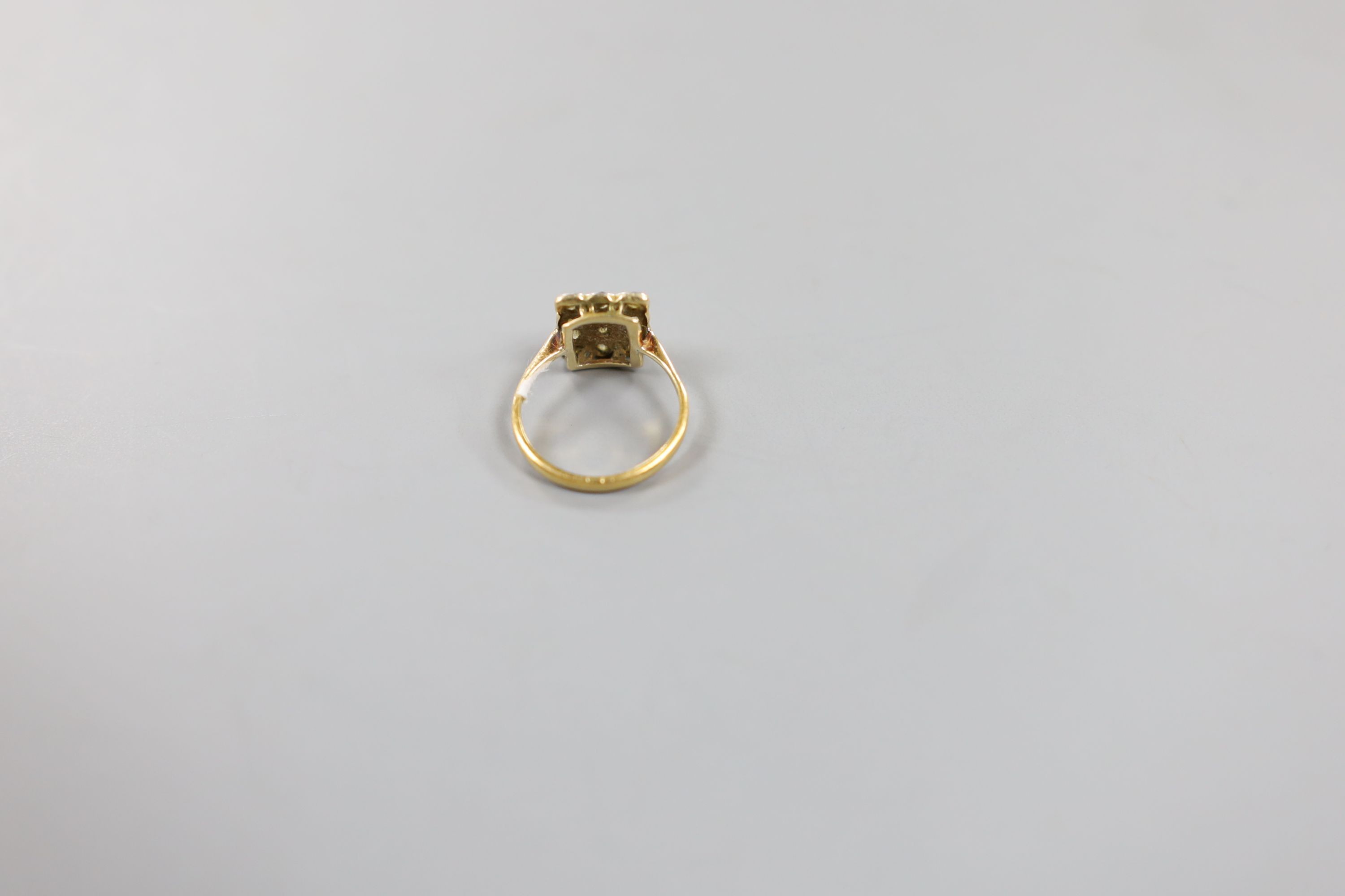A 1920's yellow metal and diamond cluster set tablet ring, size F, gross weight 2.3 grams.
